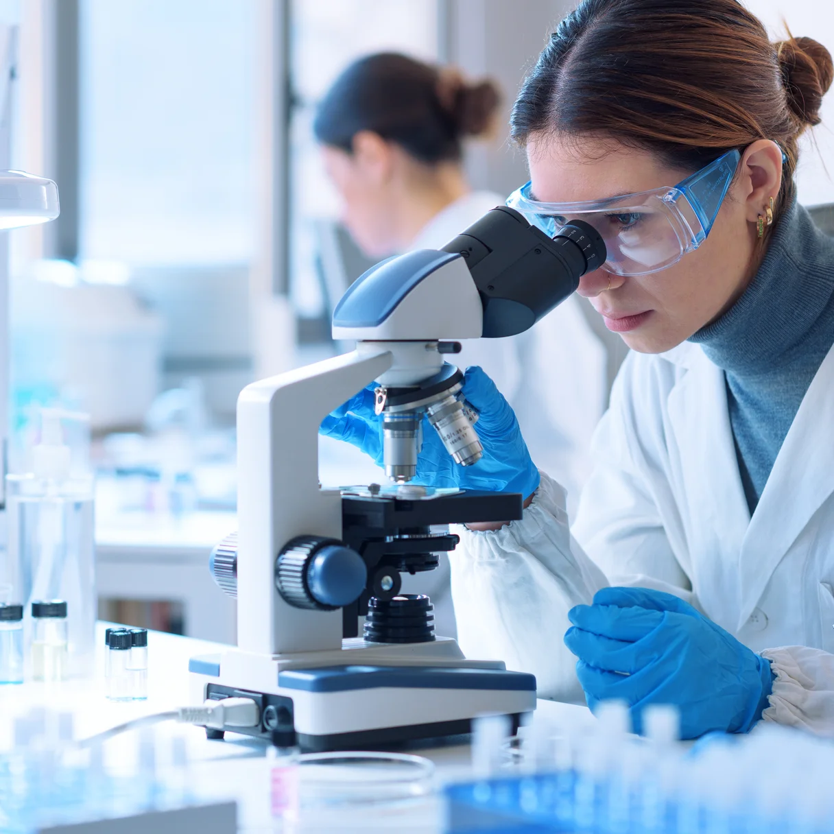 Técnica de laboratorio analizando una muestra al microscopio